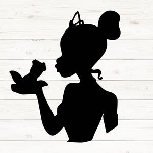 May include: Black silhouette of a person with a bun, tiara, and a bird in their hand. The person is blowing a kiss towards the bird. The image is set against a white wooden background.