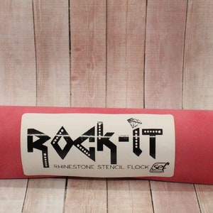 May include: A red roll of rhinestone stencil flock with a white label that says "Rock-It Rhinestone Stencil Flock Set".
