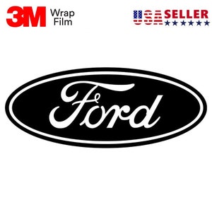 May include: Black oval Ford logo with white script lettering. The logo is set against a white background. The words "3M Wrap Film" are in the upper left corner. The words "USA SELLER" are in the upper right corner.