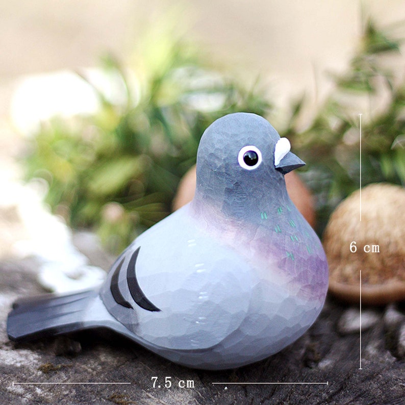 以下が含まれることがあります： 手彫りの木製の鳩の置物で、グレーとパープルのペイントが施されています。鳩の長さは7.5cm、高さは6cmです。