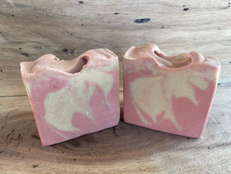 May include: Two bars of handmade soap with a pink and white swirl pattern. The soap is made with natural ingredients and is perfect for sensitive skin.