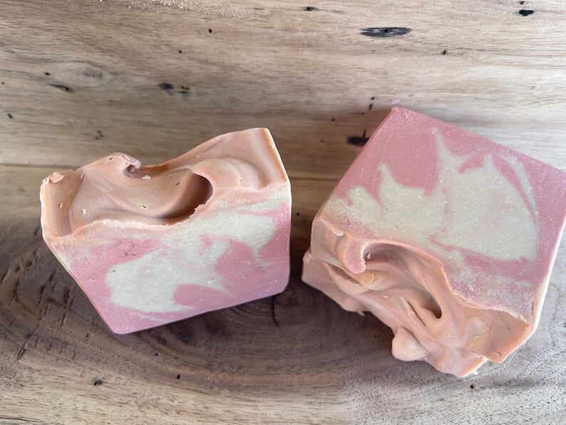 May include: Two bars of handmade soap with a pink and white swirl pattern. The soap is made with natural ingredients and is perfect for sensitive skin.