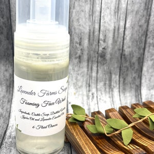 May include: A clear plastic bottle of Lavender Farms Sage Foaming Face Wash with a white label. The label says "Lavender Farms Sage Foaming Face Wash" and lists the ingredients: "Castile Soap, Distilled Water, Jojoba Oil and Lavender Essential Oil". The bottle contains 6 fluid ounces of face wash.