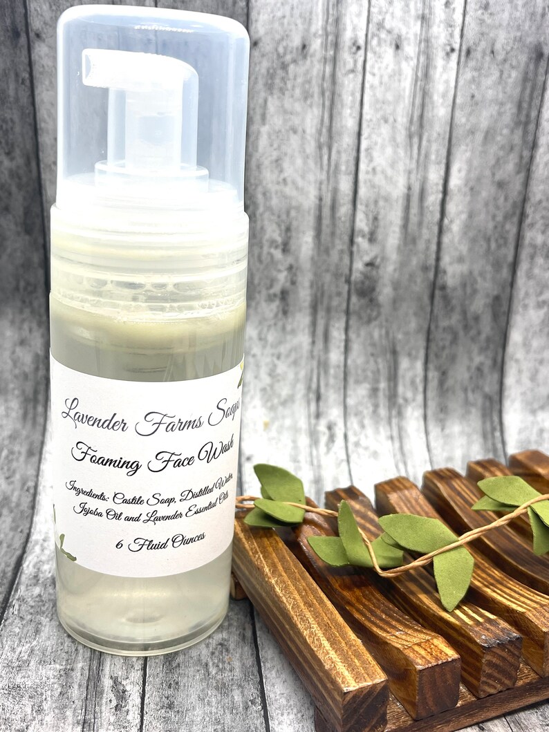 May include: A clear plastic bottle of Lavender Farms Sage Foaming Face Wash with a white label. The label says "Lavender Farms Sage Foaming Face Wash" and lists the ingredients: "Castile Soap, Distilled Water, Jojoba Oil and Lavender Essential Oil". The bottle contains 6 fluid ounces of face wash.