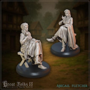 May include: Two gray miniature figurines of a woman seated, one on a stool and the other on a round base. The woman is wearing a long dress and boots. The text "Great Folks II" and "Abigail Fletcher" are visible.