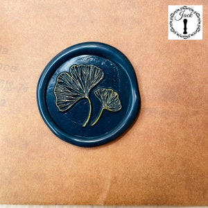May include: A dark blue wax seal with a gold ginkgo leaf design.