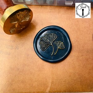 May include: A dark blue wax seal with a gold ginkgo leaf design. The seal is made with a traditional wax seal stamp.