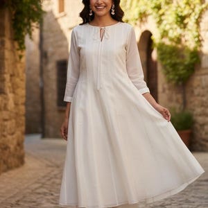 Front full-length shot, model in flowing muslin kurta with tie-neck and palazzo, white anarkali suit