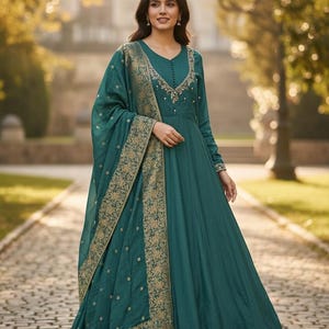 Pu&ograve; includere: Un abito formale color teal con maniche lunghe e gonna ampia. L'abito presenta uno scollo a V con ricami dorati intricati. Una scialle abbinato con bordi dorati a fantasia &egrave; drappeggiato sulle spalle. Adatto per occasioni speciali.