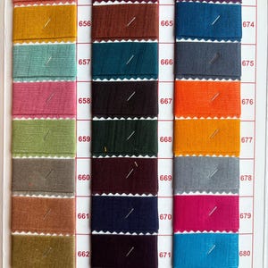 Pu&ograve; includere: Una cartella colori di campioni di tessuto con i numeri da 655 a 681. I campioni sono disposti in file di tre, con ogni fila che contiene un colore diverso.