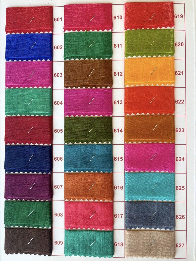 Pu&ograve; includere: Una cartella colori con 10 righe di campioni di tessuto. Ogni riga ha 3 campioni, con i numeri 601-627 etichettati sul lato destro della cartella. I campioni sono di vari colori, tra cui rosso, blu, verde, marrone, arancione, giallo, rosa, turchese, grigio e beige.