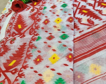 Puede incluir: Tela blanca con un estampado floral rojo y amarillo y borde rojo. La tela está doblada y tiene un ramo de rosas rojas encima. El estampado floral incluye acentos verdes y amarillos.