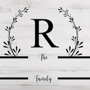May include: Black and white graphic design featuring a stylized floral wreath with the letter R in the center. The text "The Family" is below the wreath.
