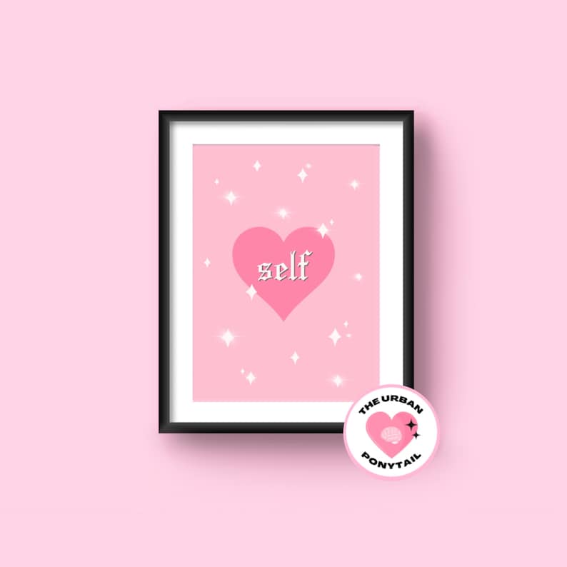 May include: Pink and white print with a pink heart and the word "self" in a gothic font. The print is framed in a black frame. The print is from The Urban Ponytail.