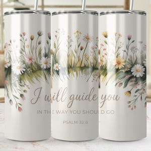 Puede incluir: Un vaso blanco con un diseño floral con margaritas y flores silvestres. El vaso tiene el texto "I will guide you in the way you should go, Psalm 32:8". Incluye una pajita plateada.