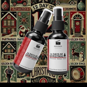 May include: Two black glass bottles with gold labels and red text. The labels read "Movie Time Scents Holidays Collection 12 Days of Christmas". The bottles are filled with scented room spray. The bottles are in front of a vintage Christmas themed background.