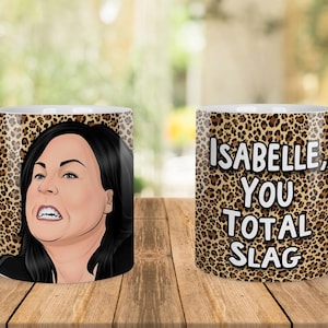 May include: White ceramic mug with a leopard print design. One side features a cartoon image of a woman with black hair and an angry expression. The other side has the text "Isabelle, You Total Slag."