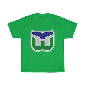 May include: Green t-shirt with a white and green whale tail logo. The logo has a blue whale tail inside the white and green.