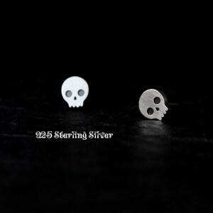 May include: A pair of silver skull stud earrings. The earrings are made of 925 sterling silver.