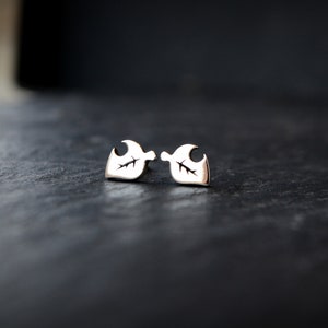 May include: A pair of silver earrings with a leaf design. The earrings are small and delicate.