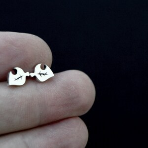 May include: A pair of silver leaf-shaped stud earrings.