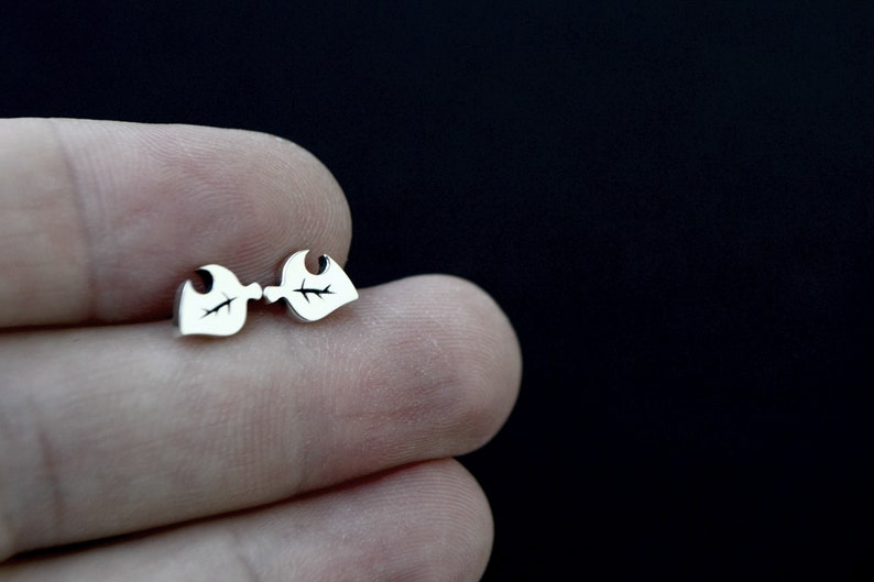 May include: A pair of silver leaf-shaped stud earrings.