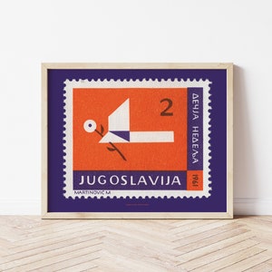 Könnte beinhalten: Eine alte Briefmarke aus Jugoslawien mit einem blauen Rand und rotem Hintergrund. Die Marke zeigt ein stilisiertes Vogelmotiv mit einer weißen Blume und dem Text "JUGOSLAVIJA" und "2 DEČIJA NEDELJA 1961".