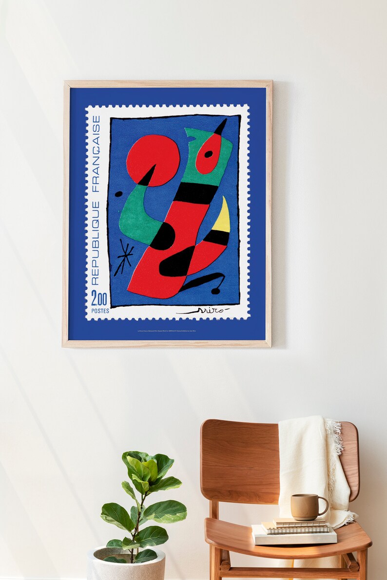 May include: A framed poster of a colorful abstract painting by Joan Mir&oacute;. The painting features a red, green, yellow, and black abstract figure on a blue background. The poster is titled "Republique Fran&ccedil;aise" and features the text "2.00 Postes".