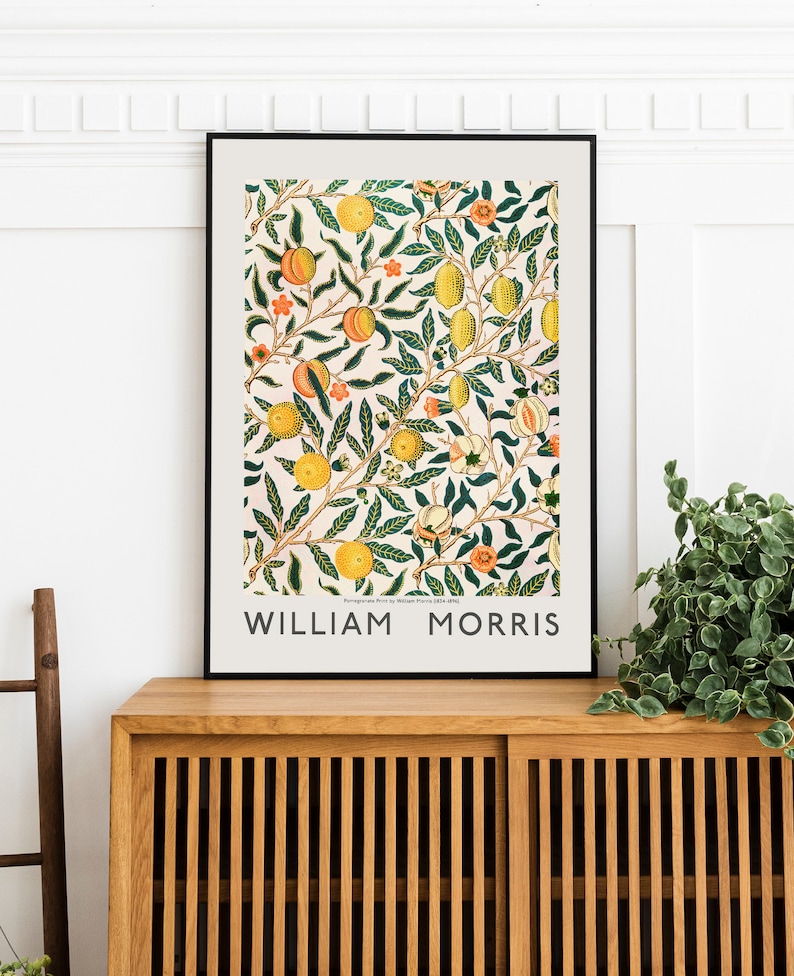 Puede incluir: Una impresi&oacute;n enmarcada de una ilustraci&oacute;n bot&aacute;nica vintage que presenta un patr&oacute;n repetitivo de hojas verdes, frutos naranjas y flores blancas. La impresi&oacute;n est&aacute; titulada "William Morris".