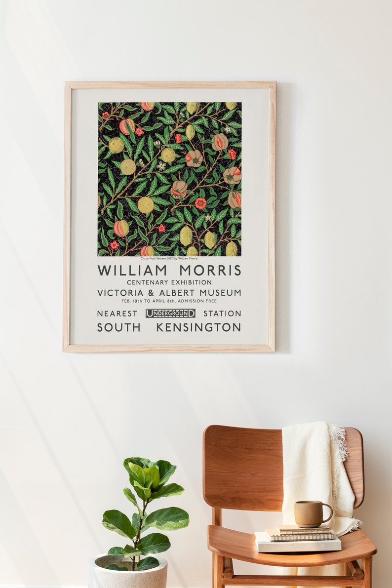 May include: A vintage poster advertising a William Morris Centenary Exhibition at the Victoria & Albert Museum in London. The poster features a black and white illustration of a citrus fruit pattern with green leaves and red flowers. The text on the poster reads "William Morris Centenary Exhibition Victoria & Albert Museum Feb. 10th to April 8th Admission Free Nearest Underground Station South Kensington."