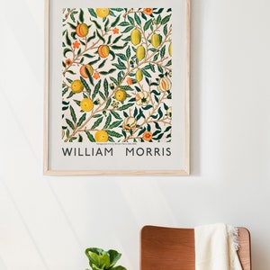 Puede incluir: Una impresi&oacute;n enmarcada de una ilustraci&oacute;n bot&aacute;nica vintage con un patr&oacute;n repetitivo de hojas verdes, limones amarillos y melocotones naranjas. La impresi&oacute;n est&aacute; titulada "WILLIAM MORRIS".