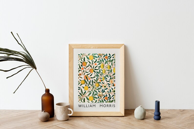 Puede incluir: Una impresi&oacute;n enmarcada de un patr&oacute;n floral con frutas y hojas de color naranja, amarillo y verde. La impresi&oacute;n est&aacute; titulada "William Morris".