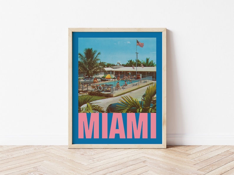 May include: Framed print featuring a vintage-style image of a pool scene in Miami. The image is set against a blue background with the word "MIAMI" in pink block letters at the bottom. Palm trees and an American flag are visible.