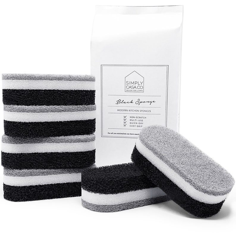 May include: A package of six black kitchen sponges with a white and gray scrubbing surface. The package is labeled "Simply Casa.co Black Sponge Modern Kitchen Sponges" and lists features like "Non-Scratch", "Multi-Use", "Quick-Dry", and "Easy Grip".