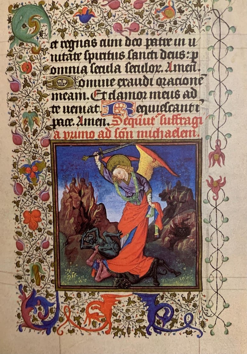 A medieval manuscript page with a hand-painted illustration of an angel with a sword defeating a demon. The angel is depicted with wings, a halo, and a long red robe. The demon is green and has horns. The text on the page reads: 'et nynas aim deo patir in u utate spurtus fancti dais:p omnia lauda fenilor. Amen. Хотше стаиdi radone meam. Erdamos mais ad to uemat equideantr paa. Amen.equut luftragi a vumo ad lon muchadan.'