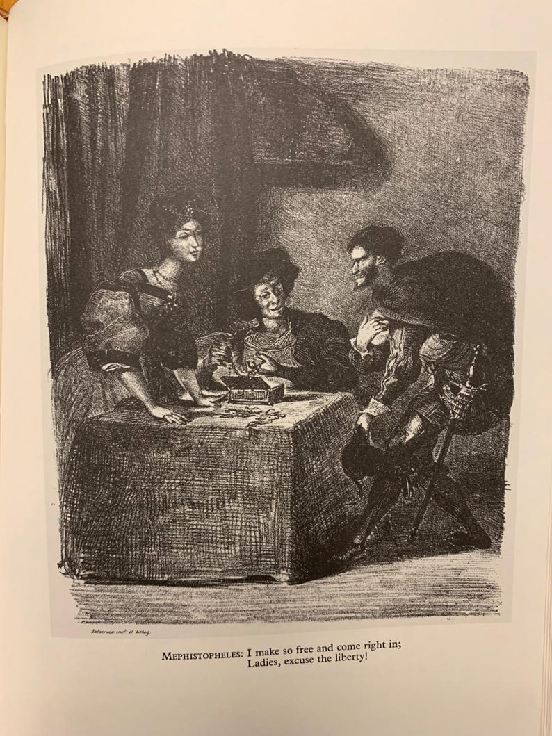 May include: A black and white illustration of a group of people sitting around a table. The people are dressed in 17th-century clothing. The text "MEPHISTOPHELES: I make so free and come right in; Ladies, excuse the liberty!" is at the bottom of the image.