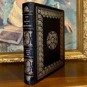 Vintage Leather-bound edition of “Tales of Mystery and Imagination” by Edgar Allan Poe with ornate gold detailing on the spine and cover. The book is displayed upright on a shelf.