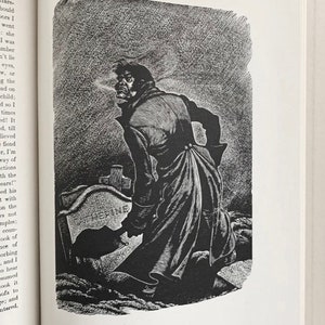 Peut inclure: Une illustration de livre en noir et blanc repr&eacute;sentant une personne en long manteau debout dans un cimeti&egrave;re la nuit. La personne tient une pelle pr&egrave;s d'une pierre tombale grav&eacute;e du nom CATHERINE. La sc&egrave;ne utilise des hachures crois&eacute;es.