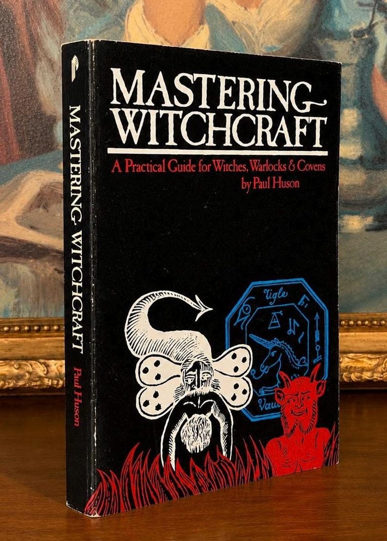 Puede incluir: Un libro de tapa dura negro titulado "Mastering Witchcraft" de Paul Huson. La portada presenta ilustraciones blancas y rojas de figuras y s&iacute;mbolos m&iacute;sticos. El lomo tambi&eacute;n muestra el t&iacute;tulo y el nombre del autor.