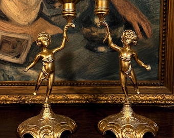 Par de candelabros antiguos dorados con querubines