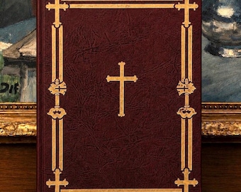 May include: A dark maroon, textured hardcover book featuring a central gold cross emblem. The cover is framed by double gold lines with decorative cross motifs at each corner and along the vertical borders, creating a structured, symmetrical design.