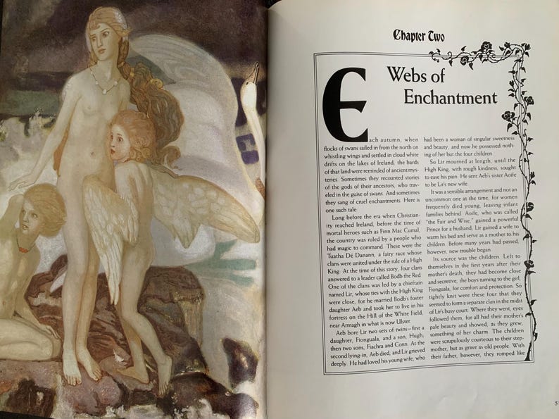 May include: An open book with an illustration of three women with wings, one of whom is riding a swan. The text on the page reads "Chapter Two Webs of Enchantment".
