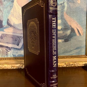 May include: A dark burgundy leather-bound book with gold accents and the title "The Invisible Man" by H.G. Wells on the spine.