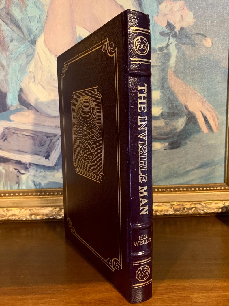 May include: A dark burgundy leather-bound book with gold accents and the title "The Invisible Man" by H.G. Wells on the spine.