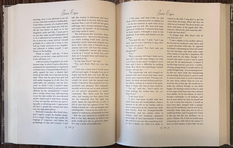 Peut inclure: Un livre ouvert &agrave; couverture rigide affichant deux pages de texte du roman Jane Eyre. Les pages sont num&eacute;rot&eacute;es 174 et 175 en bas, avec un texte imprim&eacute; en noir sur papier blanc cass&eacute;, une police &agrave; empattement et de larges marges.