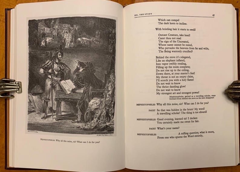 May include: A black and white illustration of a scene from the play Faust by Johann Wolfgang von Goethe. The illustration depicts a man in a long coat and hat sitting at a table with a man in a suit and hat standing next to him. The text in the image reads: "Which can compel The dark hosts to incline. With bristling hair it starts to swell Outcast Creature, take heed! Canst thou not read The sign of the Uncreated, Whose name cannot be stated, Who pervades the heavens from far and wide, The Being wantonly crucified?"