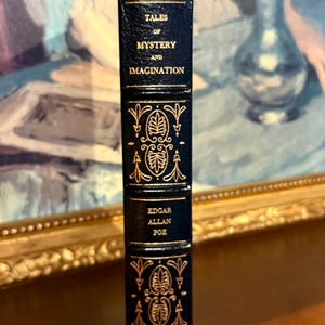 Vintage Leather-bound edition of “Tales of Mystery and Imagination” by Edgar Allan Poe with ornate gold detailing on the spine.