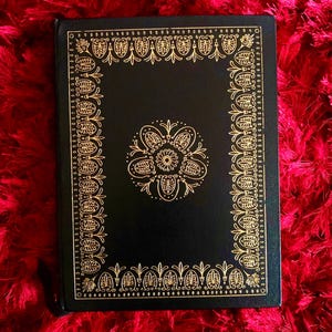 Ornate vintage leather bound book cover with gold floral design, Edgar Allan Poe collectible illustrated edition.