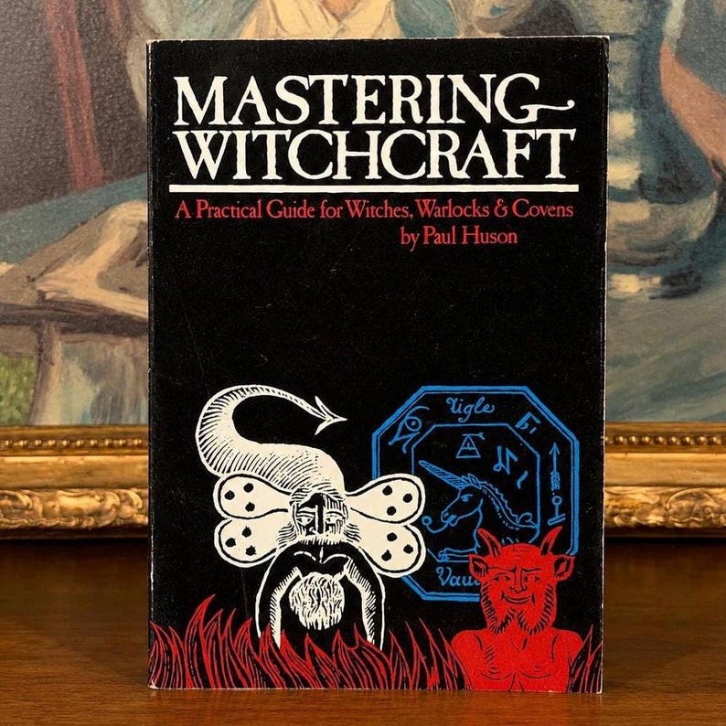 Puede incluir: Un libro antiguo titulado "Mastering Witchcraft" con una portada negra. La portada presenta ilustraciones en blanco y rojo de figuras y s&iacute;mbolos m&iacute;sticos. Tambi&eacute;n es visible el nombre del autor, Paul Huson.