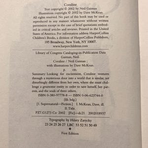 May include: The copyright page of the book Coraline by Neil Gaiman, illustrated by Dave McKean. It includes the 2002 copyright notice, Library of Congress data, a summary of the plot, ISBN numbers, and the text First Edition at the bottom.